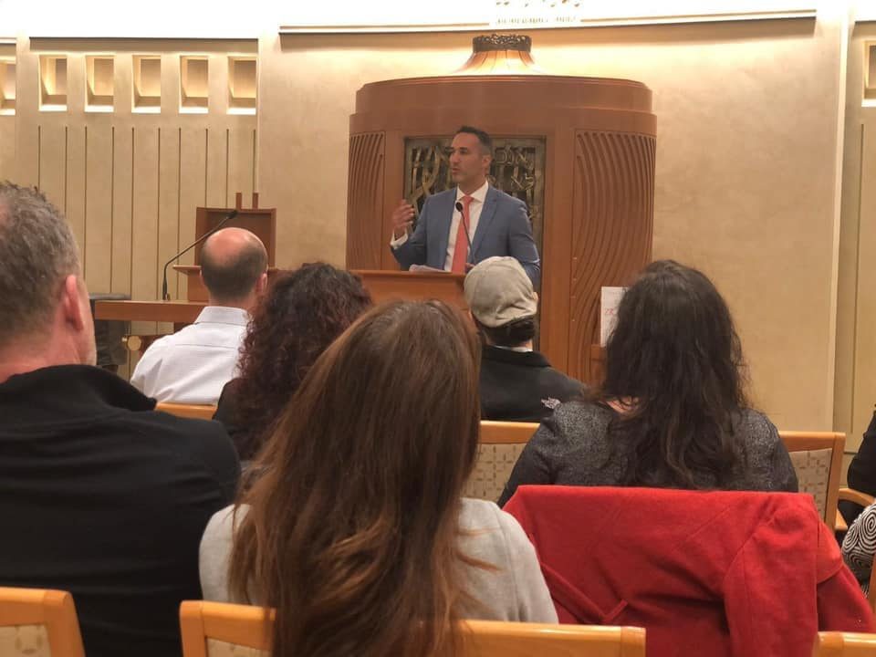 Alex Ryvchin speaking at a lectern to a seated audience during his Atlanta talk on Zionism: The Concise History.